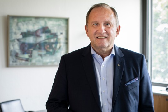 Lächelnder Mann, der im Büro steht. 