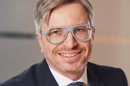 Lächelnder Mann mit grauer Brille. 