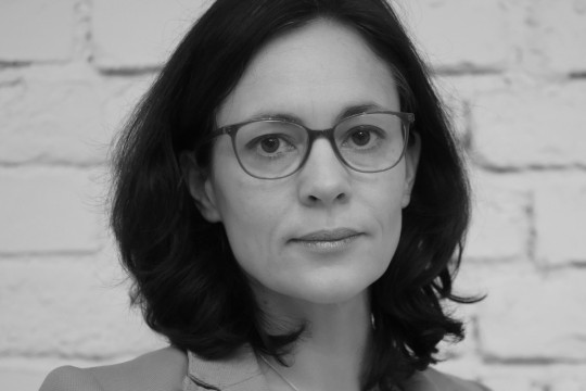 Schwarz weiß Bild einer Frau mit dunklen Haaren und Brille.