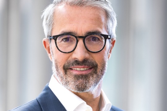 Lächelnder Mann mit dunkler Brille.